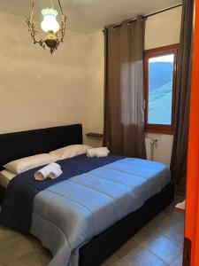 una camera da letto con un letto blu e asciugamani di Nic snow house a Roccaraso