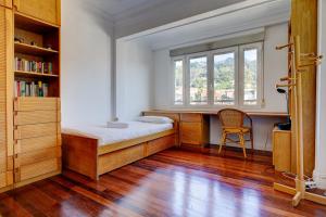 1 dormitorio con cama, escritorio y ventana en Apartamento Ulia by SanSe Holidays, en San Sebastián