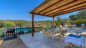 patio ze stołami i krzesłami pod pawilonem w obiekcie La Molina de la Campana Villaviciosa de Córdoba by Ruralidays w mieście Villaviciosa de Córdoba