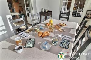 uma mesa com alimentos e bebidas para o pequeno almoço em La Closerie, Chambres d'hôtes 