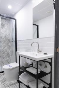 a bathroom with a sink and a toilet and a shower at Hostal Boutique I Host You in Madrid