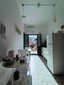 een keuken met een witte koelkast en een tafel en een tafel sidx sidx bij Va' Nedda in Lentini