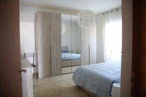 sypialnia z łóżkiem i dużym lustrem w obiekcie Appartamenti da Anna w mieście Montaquila