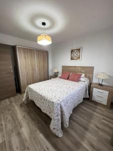 a bedroom with a bed with red pillows on it at Casa Rural "El Cañuelo" in Aljucén +15 photos