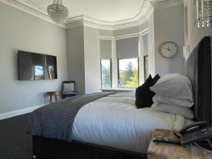 a bedroom with a large bed with a clock on the wall at The Lugton Rooms 