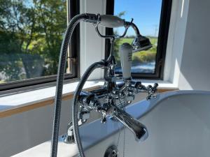 a shower head on a sink next to a window at The Lugton Rooms 