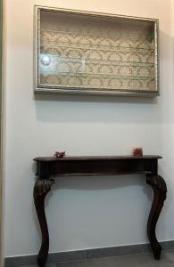 a mirror on a wall above a wooden table at App di Tania in Reggio Emilia