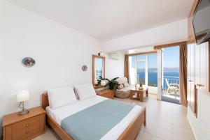 伊斯特隆的住宿－Kounenos Apartments，一间卧室配有一张床,享有海景