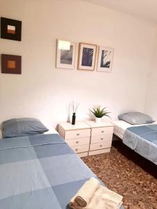 sypialnia z 2 łóżkami i komodą z 2 łóżkami w obiekcie UIM Mediterraneo M Cristina con garaje Wifi w mieście Puerto de Sagunto