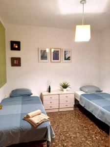 sypialnia z 2 łóżkami pojedynczymi i lampką w obiekcie UIM Mediterraneo M Cristina con garaje Wifi w mieście Puerto de Sagunto