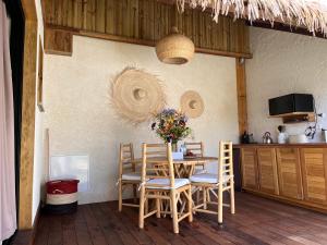 a table and chairs with a vase of flowers on it at LES VAVANGUES - L'HERMITAGE LES BAINS in La Saline les Bains