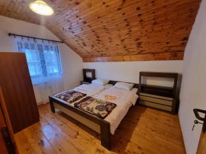 um quarto com uma cama e um tecto de madeira em Apartments Đurđić em Žabljak