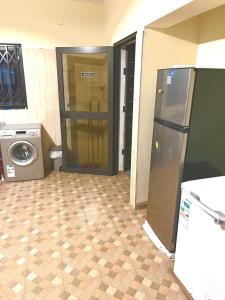 a kitchen with a refrigerator and a washing machine at CC House in Chidenguele