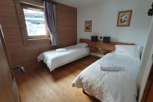 1 dormitorio con 2 camas y ventana en Tignes2100 - Le Télémark, en Tignes