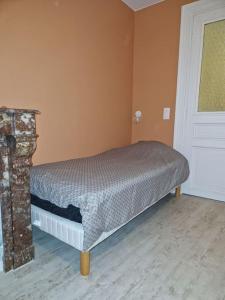 een slaapkamer met een bed in een kamer met een deur bij Bel Appart - Rez-de-chaussée - Hyper centre in Saint-Omer