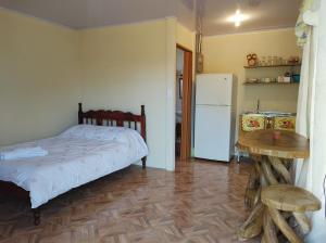 sypialnia z łóżkiem, stołem i lodówką w obiekcie The Farm's Rooms Arenal w mieście Fortuna