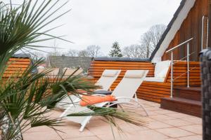 a patio with two chairs and a bed on a house at Ferienwohnung Aurora in Winsen