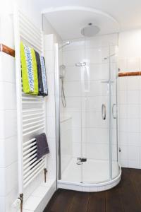 a shower in a bathroom with white tiles at Ferienwohnung Aurora in Winsen