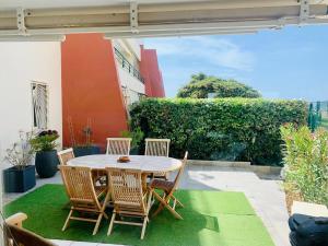 a table and chairs on a patio with green grass at ''Croisette'' Appartement rez de jardin accès direct plage ! in Sète