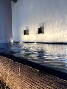 a pool of water with two monitors on a wall at The Apple PREMIER CONDO three bedroom in MELAKA in Malacca