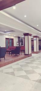 een lobby met banken en tafels in een gebouw bij Hotel Bhimas Paradise in Tirupati