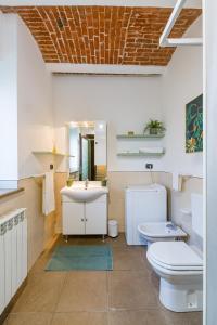 a bathroom with a sink and a toilet and a mirror at Cascina 6b in San Maurizio Canavese