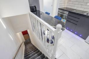 a staircase in a kitchen with a person standing on the counter at Stunning Top 2 Bed Flat Tilbury Central Location in Tilbury