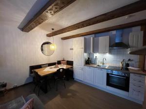 una cocina con armarios blancos y una mesa con comedor. en Haus Alpenruhe, en Bad Kleinkirchheim