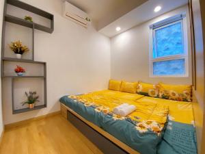 a bedroom with a yellow bed in a room at Căn hộ MELODY Vũng Tàu - Mai Oanh Homestay in Vung Tau