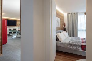 um quarto com uma cama e uma sala de estar em HelloChalet - The One - garage, bootdryer, home theatre with subwoofer, netflix, hydromassage Turkish bath em Breuil-Cervinia