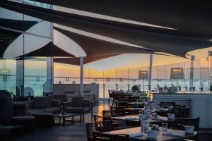 リスボンにあるマイリアド バイ サナ ホテルズのテーブルと椅子が備わるレストランで、水辺の景色を望めます。