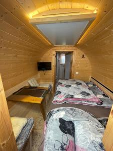 a room with two beds and a tv in a cabin at Haus Geyken / Finnen Fass in Südbrookmerland