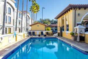 een zwembad tussen twee gebouwen met palmbomen bij Best Western Historical Inn in St. Augustine