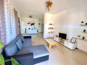 a living room with a blue couch and a tv at Tarrafal Odyssea in Tarrafal