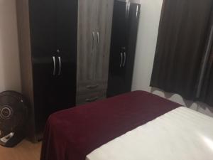 a bedroom with a bed and some black cabinets at APT A 10 MIN DA CIDADE DE PENEDO in Resende