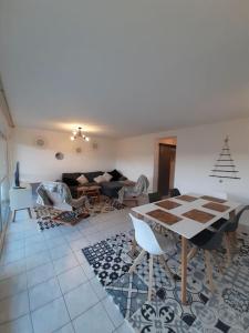 a living room with a table and a couch at BALCONS du LAC in Gérardmer