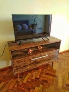 TV en la parte superior de una cómoda de madera en Amplio depto de 2 dormitorios, Zona Plaza Uruguaya, en Asunción