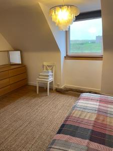 a bedroom with a bed and a window and a table at Harbourside Apartment in Eyemouth
