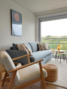 a living room with a couch and a chair at Studio 3 Bredene met strandcabine in Bredene