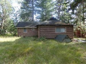 a small log cabin in the middle of a field at O Me, O Mio Cabin near the AuSable River in Mio