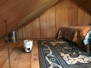 a bedroom with a bed and a rug in a attic at O Me, O Mio Cabin near the AuSable River in Mio