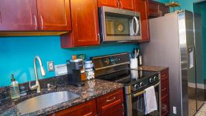 a kitchen with a sink and a stove and a refrigerator at Franklin Park condo 5 mins from airport, Walk to Conservatory in Columbus