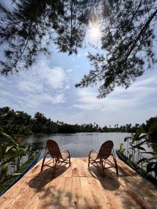 due sedie sedute su un molo vicino a un corpo d'acqua di My Paradise ad Ahangama