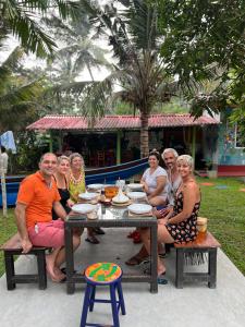 un gruppo di persone seduti a un tavolo da picnic di My Paradise ad Ahangama