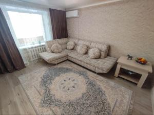 ein Wohnzimmer mit Sofa und Tisch in der Unterkunft 2-х комнатная квартира в центре на ул.Бородина 107 in Qostanai