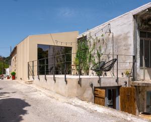 a building with a balcony with a chair on it at Casa Coo in Dhafnédhes