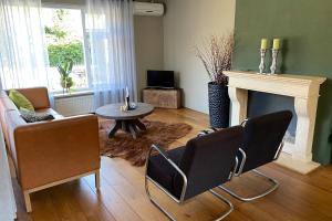 een woonkamer met een open haard en een tafel en stoelen bij 't Achterhuis (2 persons) in Otterlo