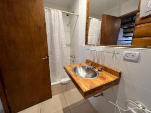 uma casa de banho com um lavatório de madeira e um espelho em Hostería y Cabañas Quime Quipan by Nordic em San Carlos de Bariloche