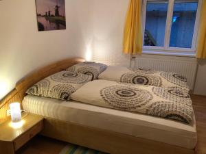 een bed met twee kussens en een raam bij Haus Konzett in Klösterle am Arlberg