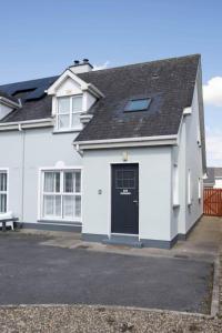 a white house with a black door at Modern newly refurbished house 10 minute walk from Lahinch in Lahinch
